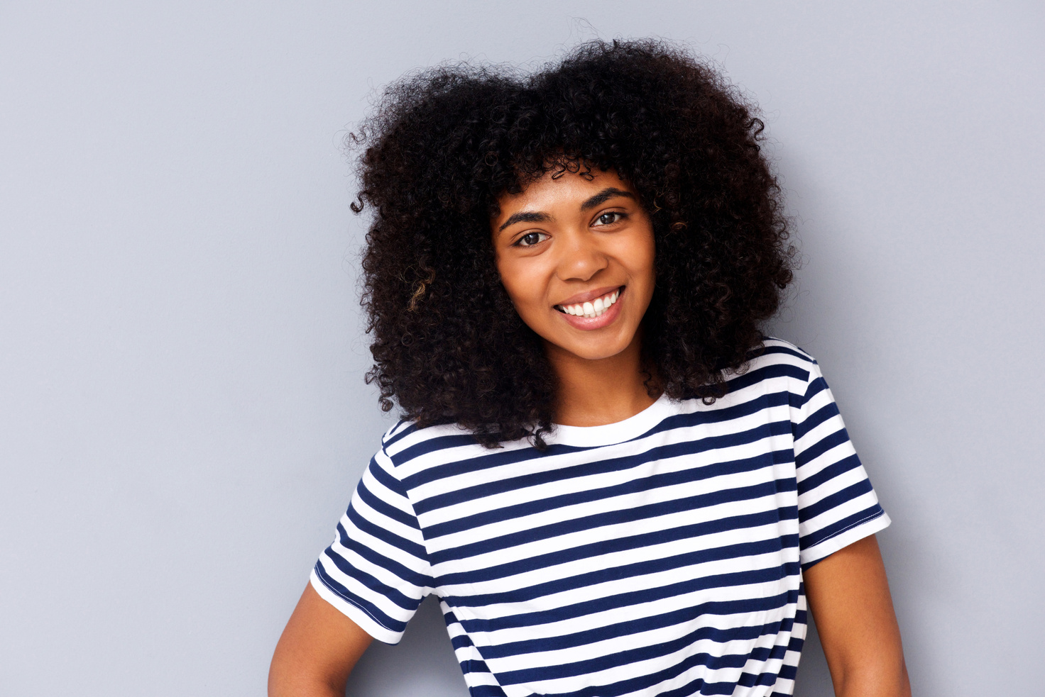 Smiling Woman with Afro Hair Wearing Striped Shirt